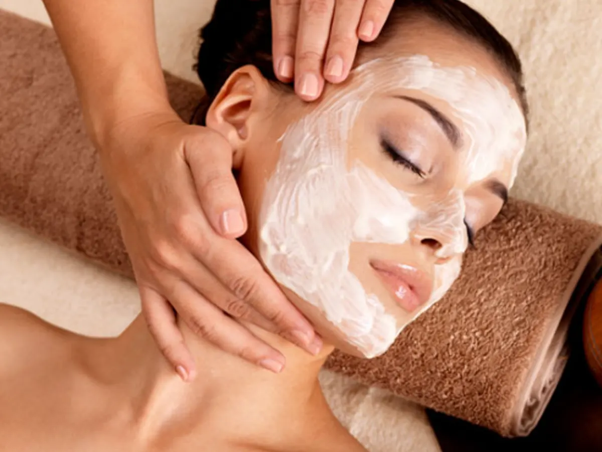 Woman receiving a facial peel treatment in a spa or clinic setting.